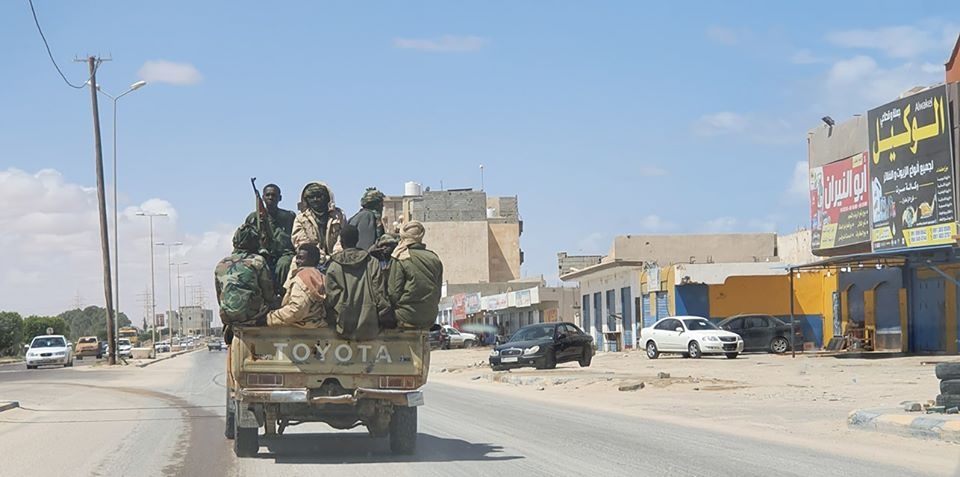 Sudanese mercenaries ride on a pickup truck in the city of Sirte